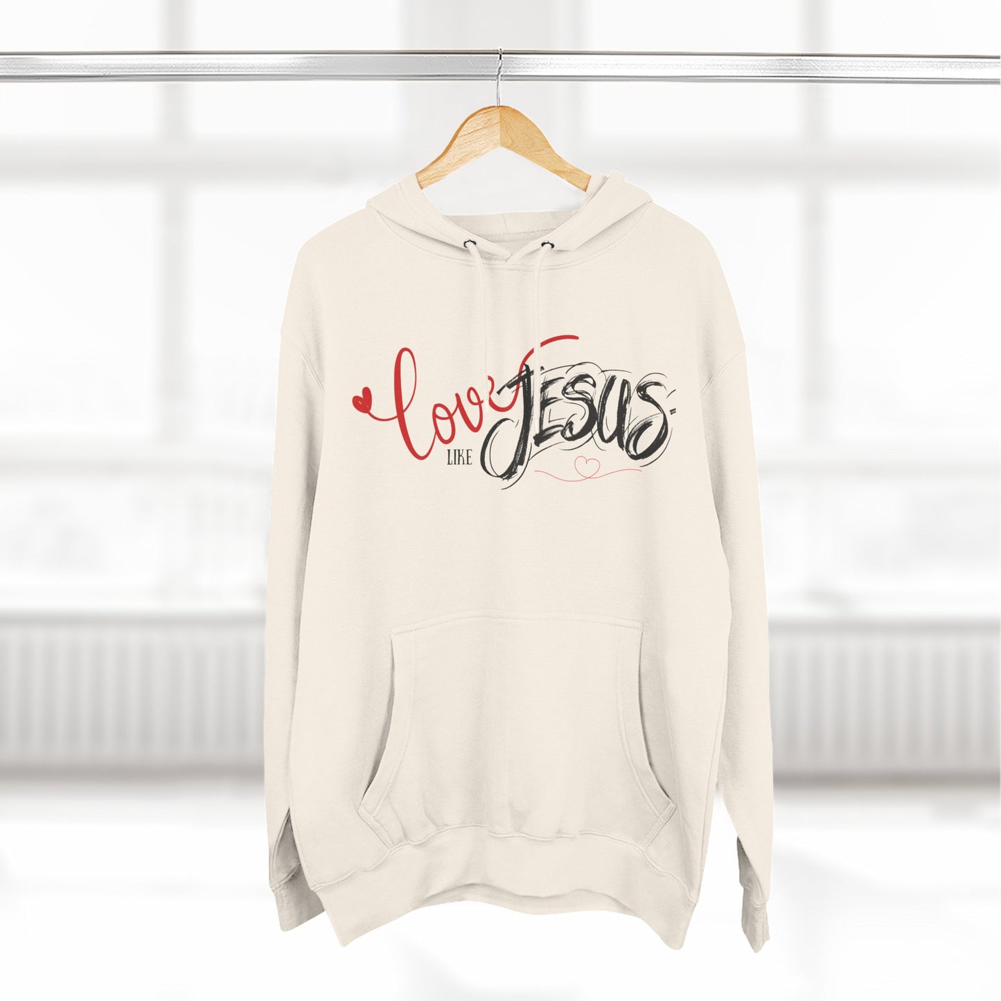 Beige hoodie with 'Love like Jesus' text on a hanger against a white background