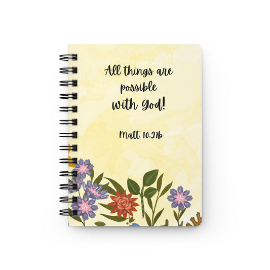 Notebook with floral design and a Bible verse on a white background