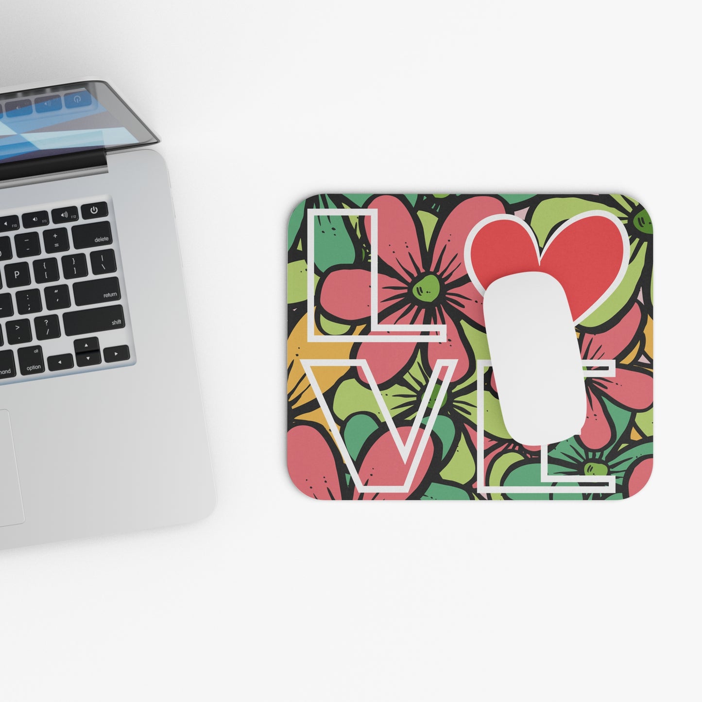 Colorful 'LOVE' design on a square card next to a laptop