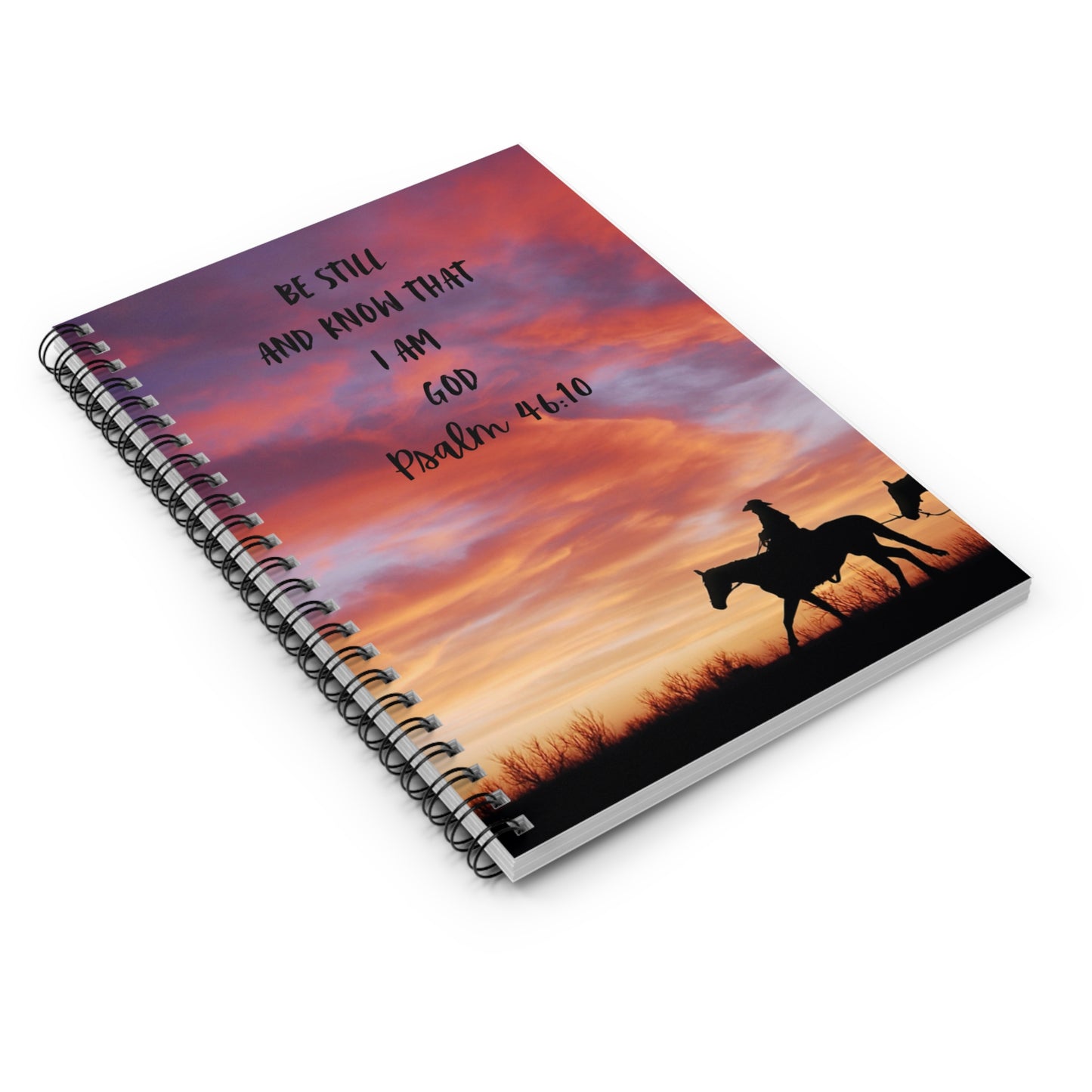 Notebook with a sunset design and silhouette of a person on a horse, featuring a Bible verse.