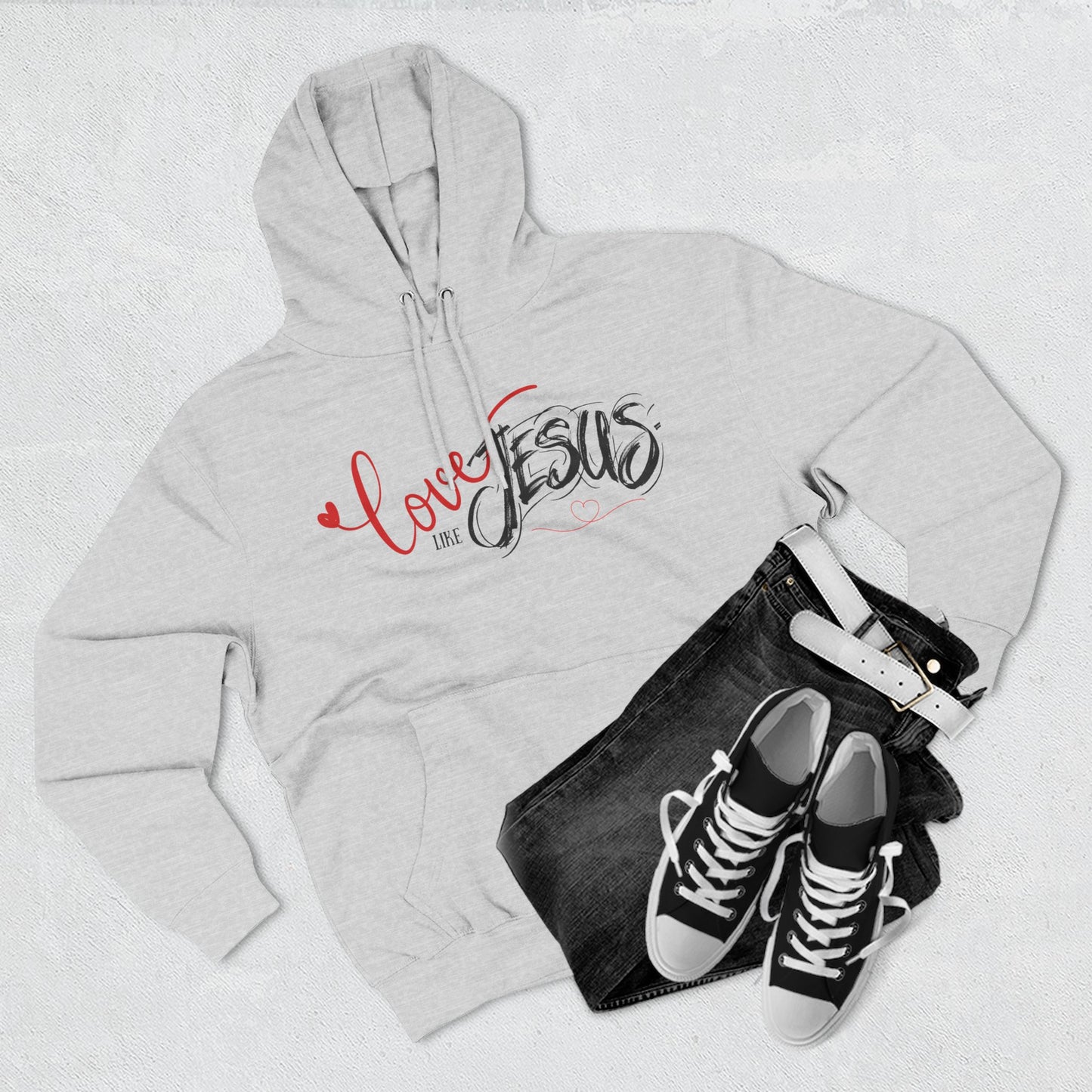 Gray hoodie with 'Love Jesus' text, black jeans, and black sneakers on a light gray background