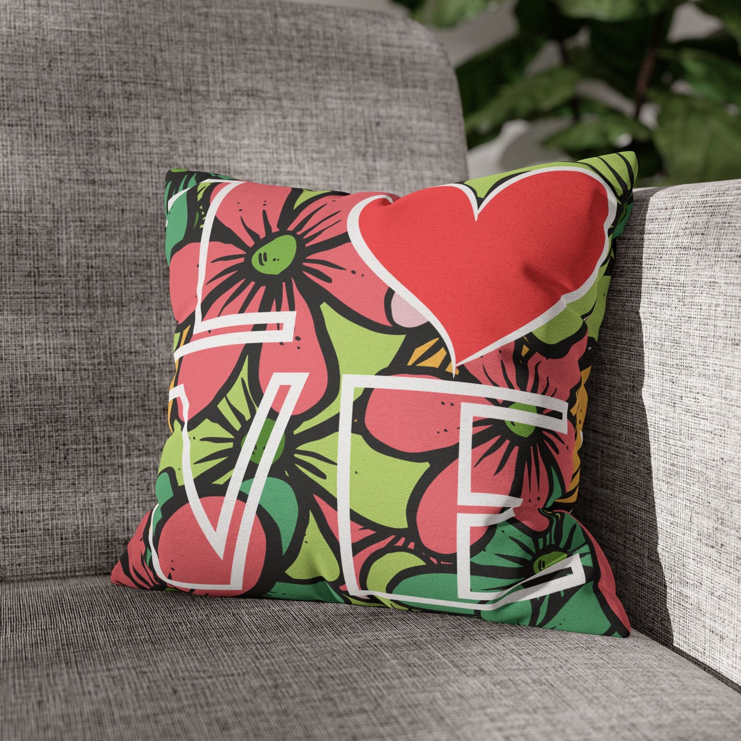Decorative pillow with floral and heart design and the word Love on a gray couch