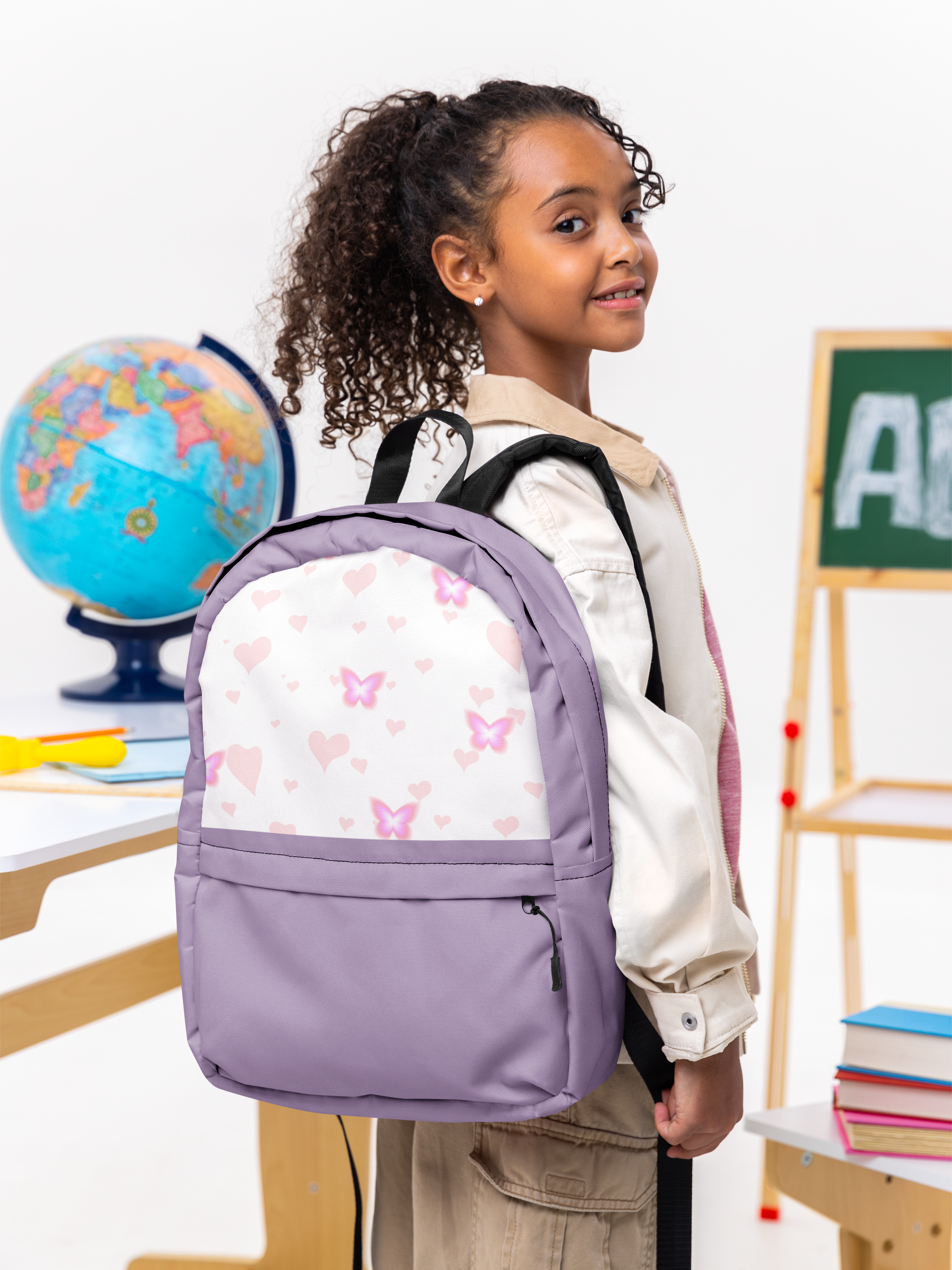 Girl wearing a purple backpack with butterfly design in a classroom setting