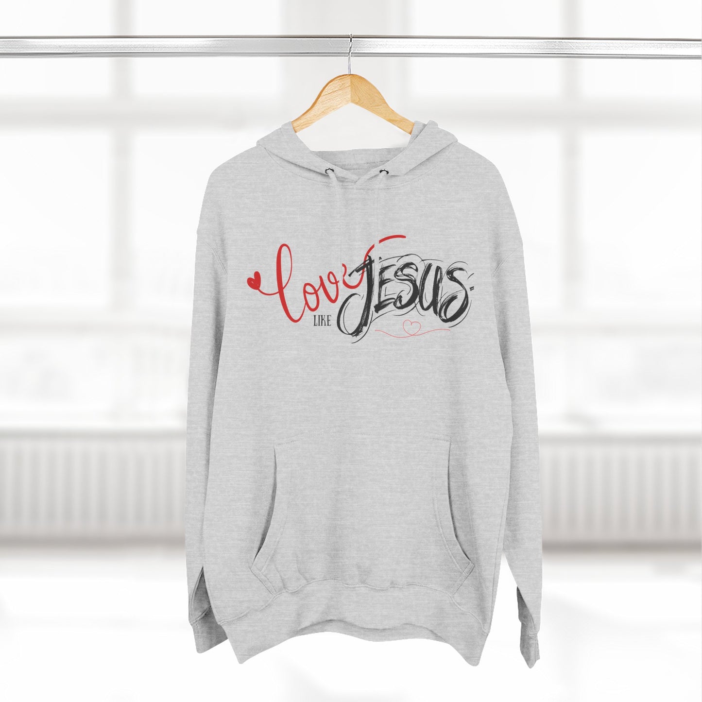 Gray hoodie with 'Love like Jesus' text on a hanger against a white background