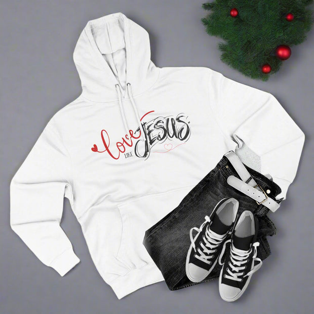 White hoodie with 'Love Jesus' text, black jeans, and black sneakers on a light gray background