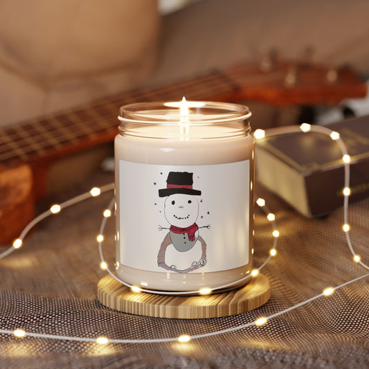 Candle with a snowman label on a wooden coaster surrounded by string lights and a guitar in the background