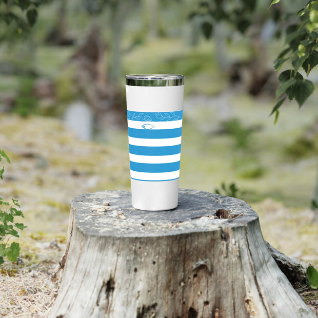 Tumbler with blue stripes on a wooden stump outdoors