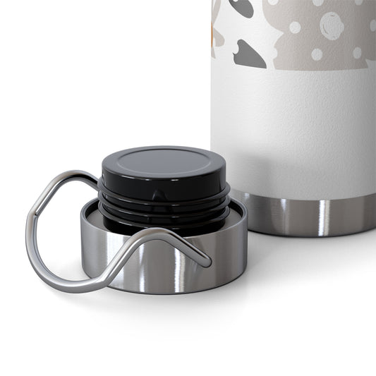 Close-up of a silver and black lid with a white container featuring gray polka dots in the background.