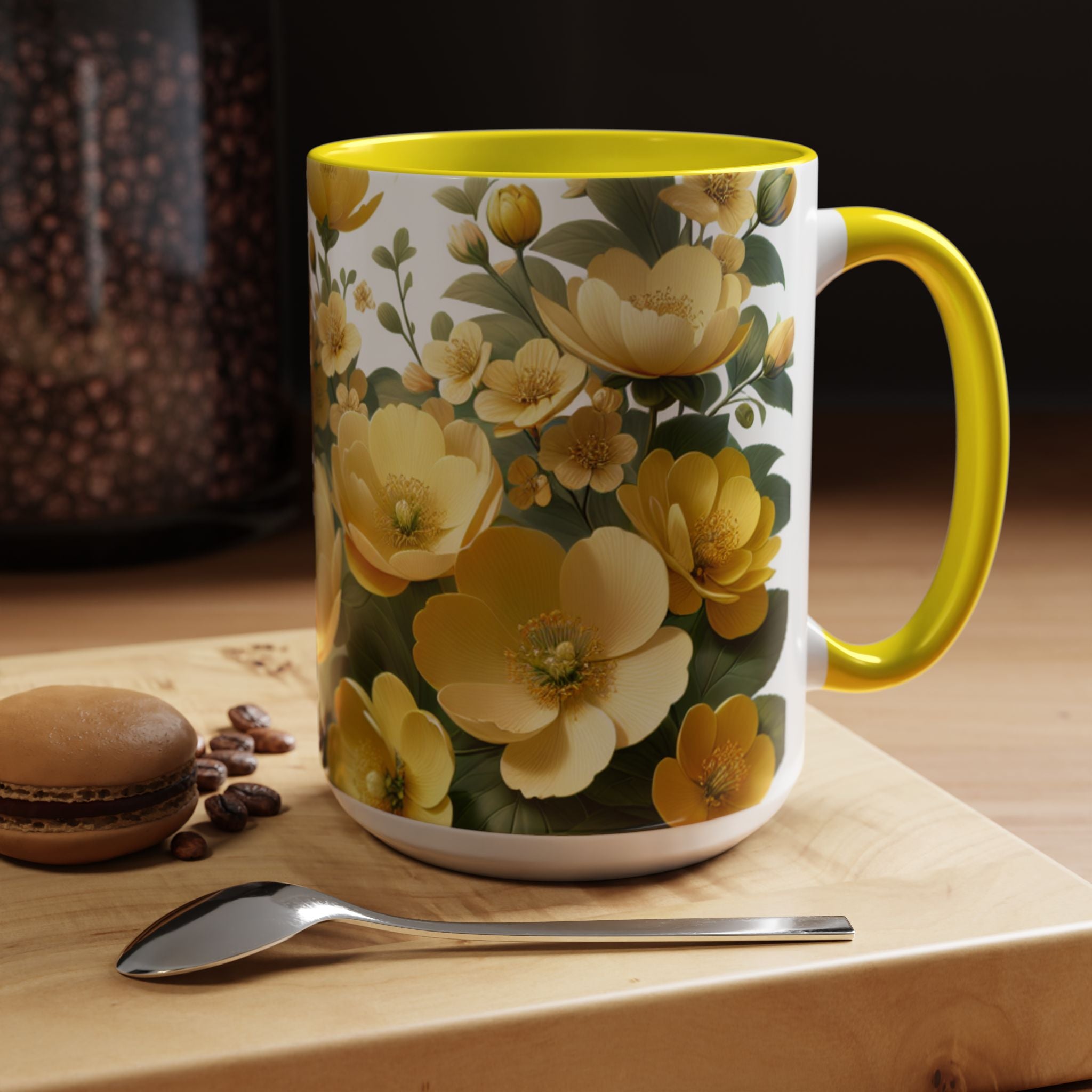 Floral mug with yellow flowers on a wooden surface with coffee beans and a macaron.