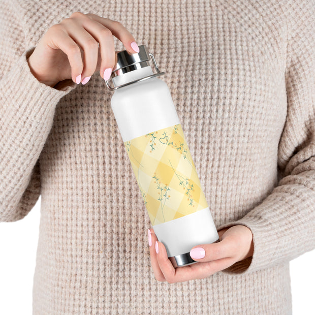 Person holding a white water bottle with a yellow pattern