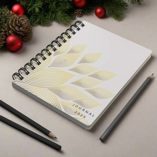2025 Journal with geometric design on a gray desk with pencils and a plant.
