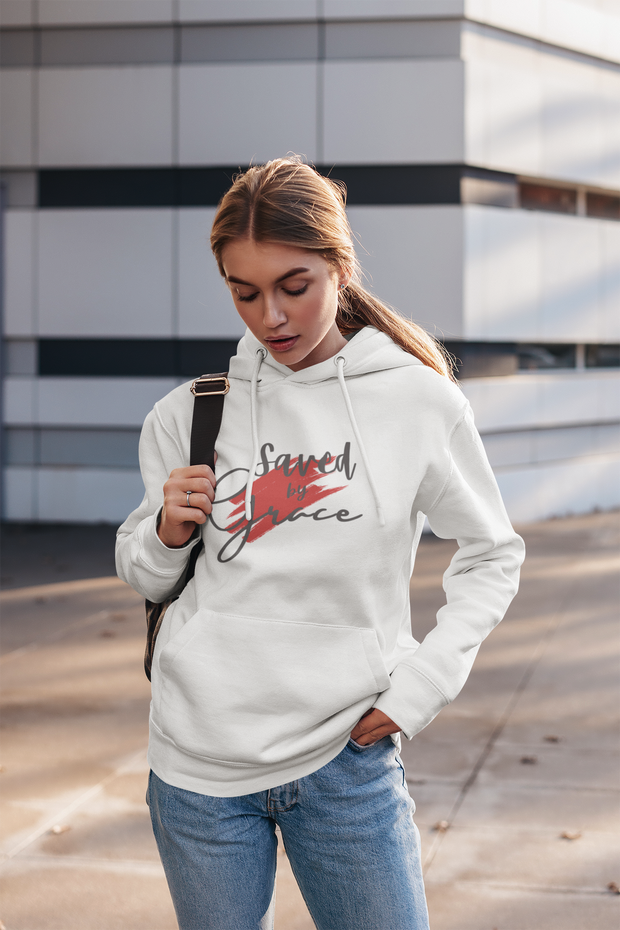 Woman wearing a white hoodie with text, standing outdoors.