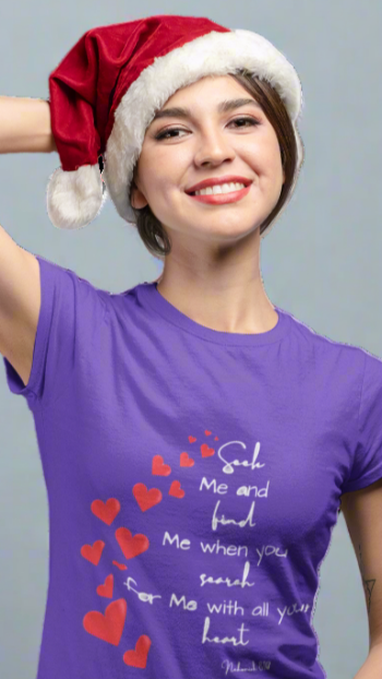 Person wearing a purple t-shirt with text and red hearts, and a Santa hat on a white background