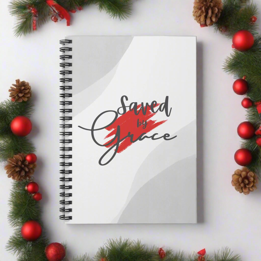 Notebook with 'Saved by Grace' text on a white background