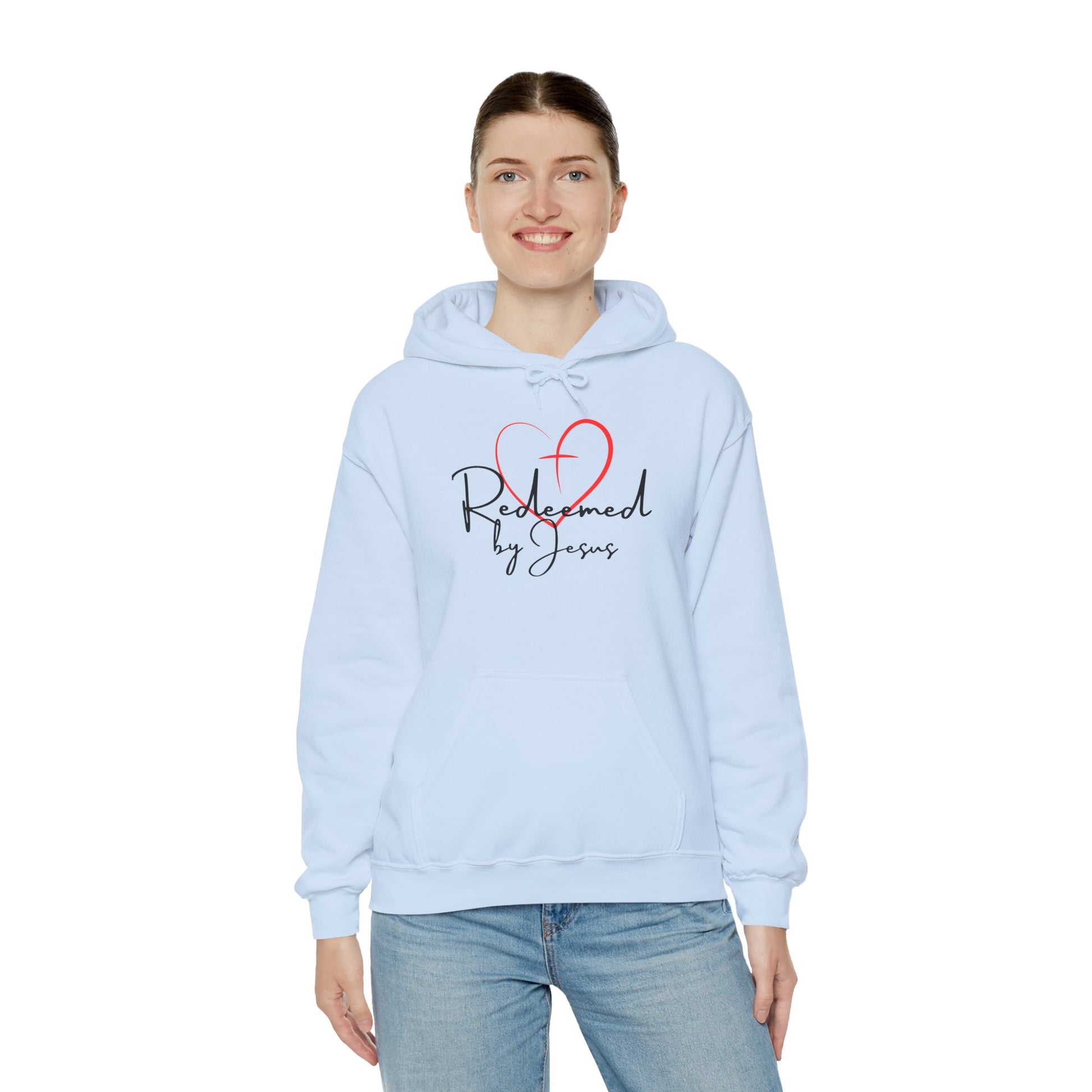 Person wearing a light blue hoodie with 'Redeemed by Jesus' text and heart design on a white background