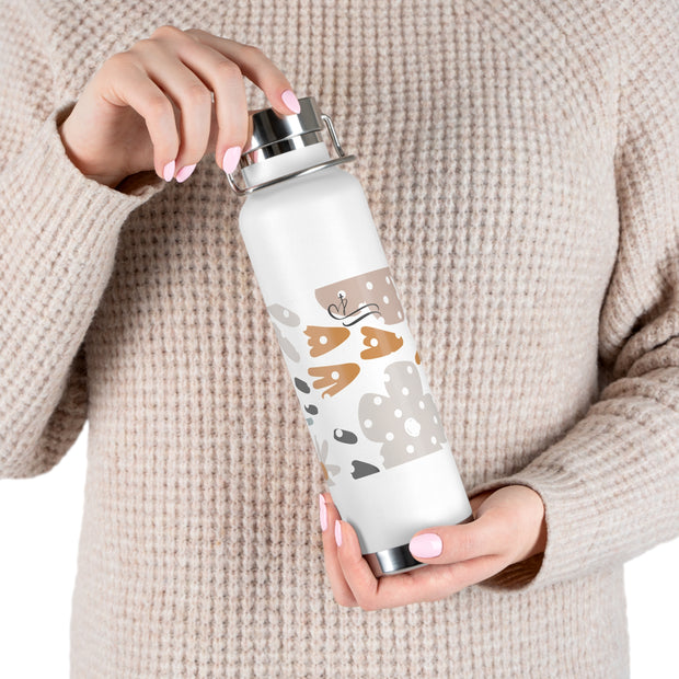 Person holding a white water bottle with animal prints against a beige background