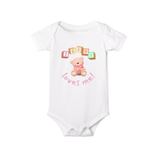 White baby onesie with 'Jesus loves me' text and teddy bear graphic on a white background